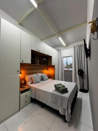 a bedroom with a large bed with a wooden headboard at Loft Oriente - 800m do Parque das Águas in São Lourenço