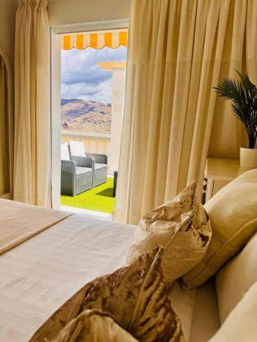 a bedroom with a bed and a sliding glass door at Atlantic Ocean & Beach Views - Playa Del Cura in Las Palmas de Gran Canaria