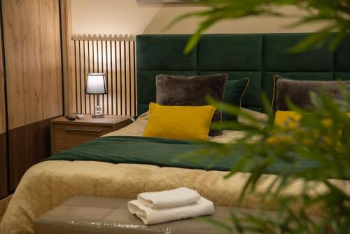 a bedroom with a bed with a green headboard and yellow pillows at A Casa dos Sonhos in Chaves