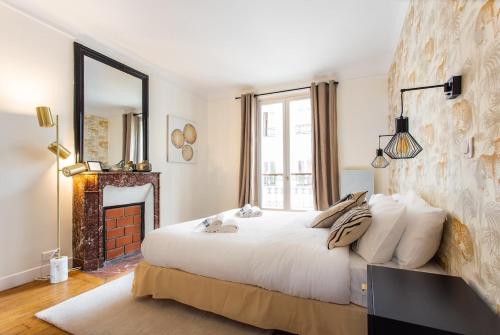 - une chambre avec un grand lit blanc et une cheminée dans l'établissement Montmartre Seveste Beautiful Apartment 2BR, à Paris