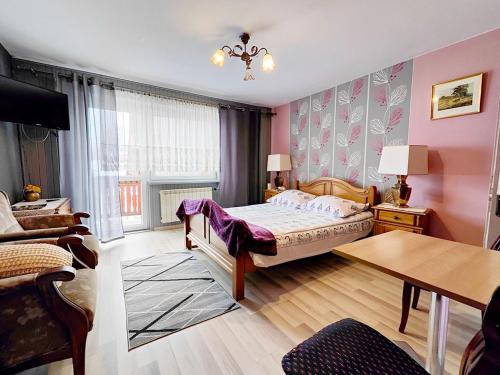 a bedroom with a bed and a table in a room at U Dany in Białka Tatrzanska