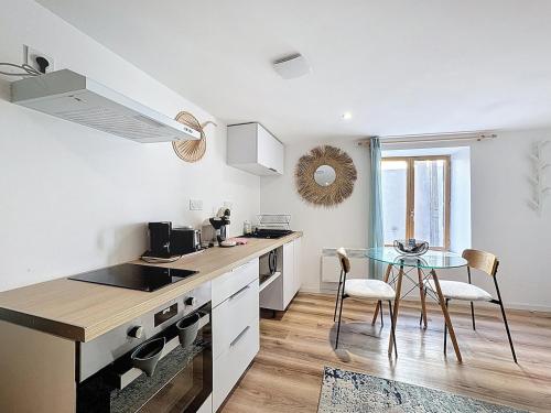 une cuisine avec une table et un comptoir en verre dans l'établissement Séjour tout confort dans un appart cosy Aulnat 1, à Aulnat