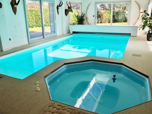 einen Innenpool mit blauem Wasser in einem Haus in der Unterkunft Villa piscine intérieure in Le Touquet-Paris-Plage