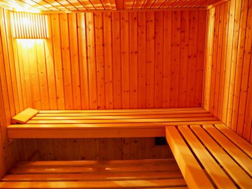 eine Holzsauna mit einer Holzbank in der Unterkunft Villa piscine intérieure in Le Touquet-Paris-Plage