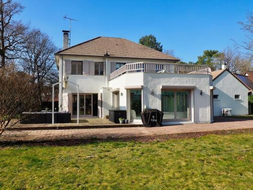 une grande maison blanche avec un toit dans l'établissement Villa piscine intérieure, à Le Touquet-Paris-Plage