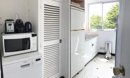 La cuisine est équipée d'un réfrigérateur blanc et d'un four micro-ondes. dans l'établissement Plage Benoit La Baule 4 pers Casino, à La Baule