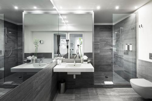 a bathroom with two sinks and a shower at LHP Hotel Montecatini Palace & SPA in Montecatini Terme