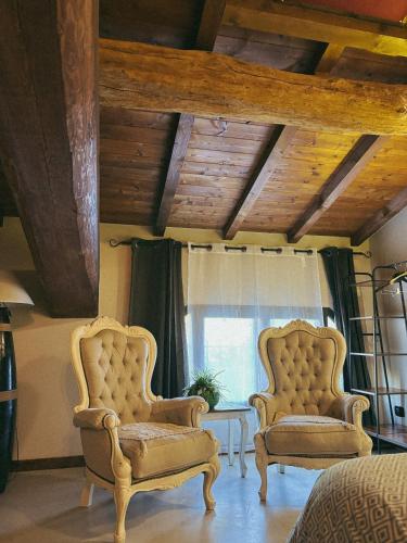 two chairs sitting in a room with a window at Il Fienile B&B in Guastalla