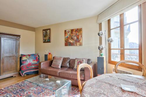 un salon avec un canapé et une table dans l'établissement Lovely 1 BR near Sacré-Coeur Basilica, à Paris