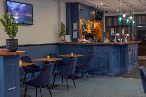 a bar with wooden tables and chairs in a restaurant at Hotel St Pierre, Sure Hotel Collection by Best Western in Wakefield