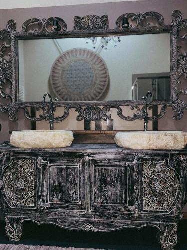 a mirror with two sinks on top of a dresser at Il Fienile B&B in Guastalla