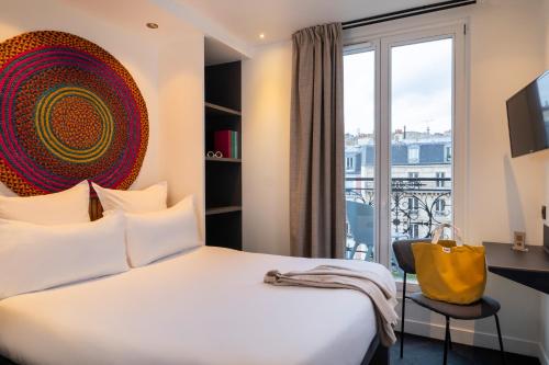 a hotel room with a bed and a large window at Korner Saint Marcel in Paris