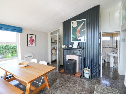 Una sala de estar con una mesa y una chimenea. en The Sleepy Shell, en Ballydavid