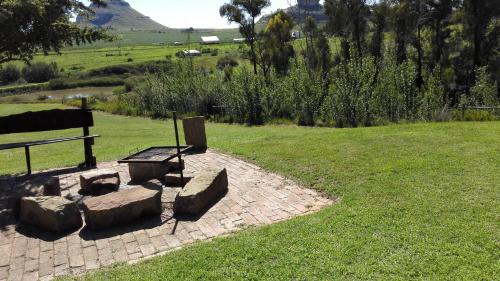 a park with a bench and some rocks and grass at Pumula Guest Farm in Fouriesburg