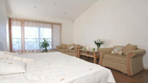 a bedroom with a bed and two chairs and a window at Tenisa klubs Jūra in Jūrmala