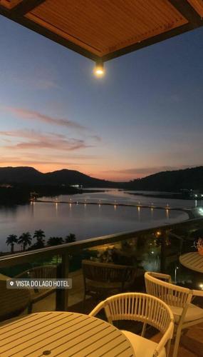 a balcony with a view of a lake at night at Vista do Lago Hotel in Capitólio