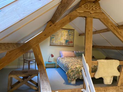 Habitación en el ático con cama y silla en Pluk het Geluk, en Laag-Soeren