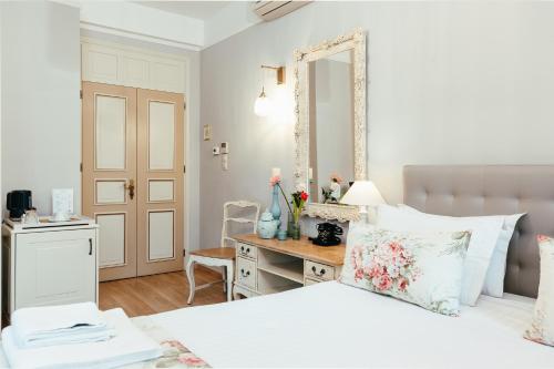 a bedroom with a bed and a desk with a mirror at Hotel Kastro in Ioannina