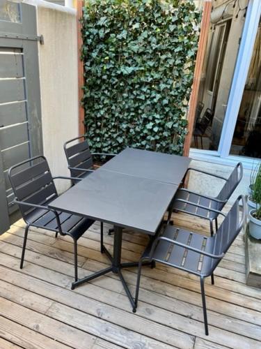 une table et des chaises assises sur une terrasse dans l'établissement La Terrasse hyper centre près des Halles, à La Rochelle