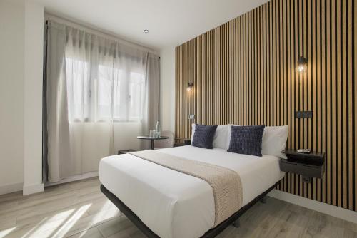 ein Schlafzimmer mit einem großen weißen Bett und einem Fenster in der Unterkunft Dobo Madrid Lucero in Madrid