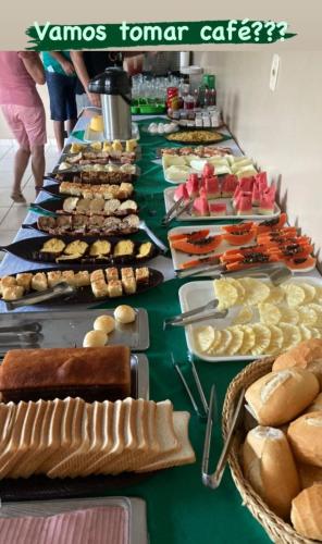 einem langen Tisch mit verschiedenen Lebensmitteln in der Unterkunft Pousada Vila da Praia in Santarém