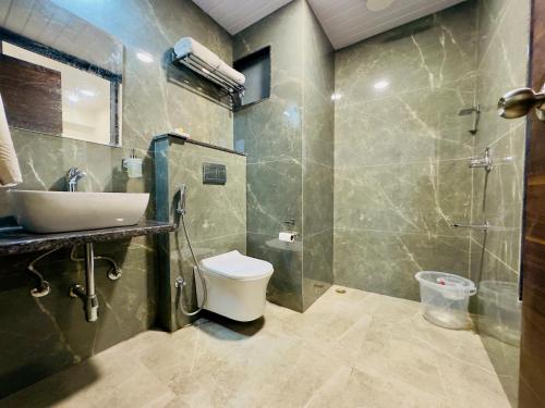 a bathroom with a sink and a toilet and a shower at Hotel The Dee Glanc - A Pure Veg Hotel near Bus stand Udaipur in Udaipur