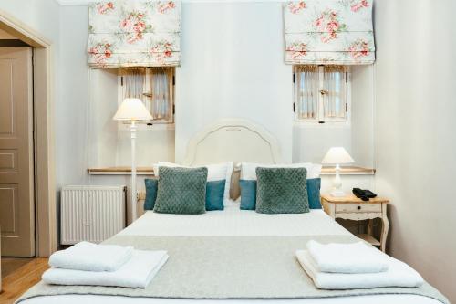 una camera da letto con un letto bianco con cuscini blu di Hotel Kastro a Ioannina