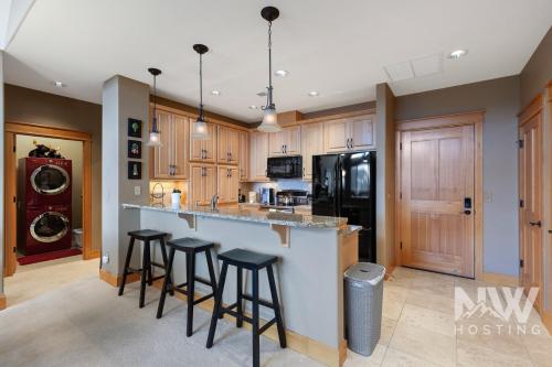 a kitchen with wooden cabinets and bar stools at RC 309 Riverstone Village in Coeur d'Alene