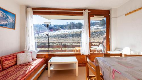 une chambre avec un canapé, une table et une fenêtre dans l'établissement Les Eterlous N07 - 2P5, à Morillon