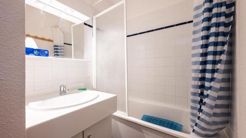 une salle de bain blanche avec un lavabo et une douche dans l'établissement Les Eterlous N07 - 2P5, à Morillon