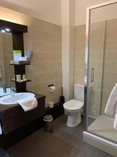 ein Badezimmer mit Toilette, Waschbecken und Dusche in der Unterkunft Hôtel du Midi in Annonay