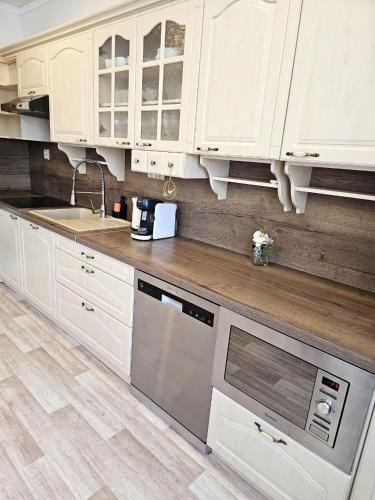 a kitchen with white cabinets and stainless steel appliances at Prostorný apartmán v centru - Wi-Fi, Netflix in Hradec Králové