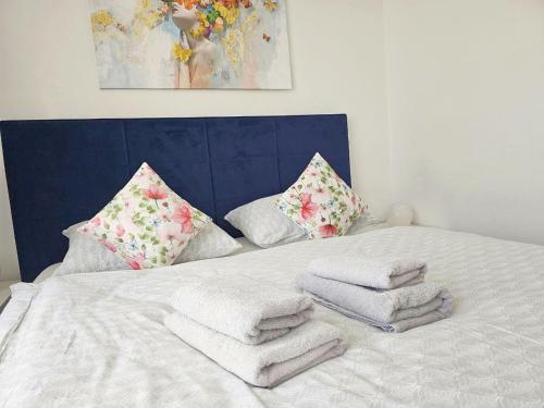 a white bed with towels and pillows on it at Prostorný apartmán v centru - Wi-Fi, Netflix in Hradec Králové