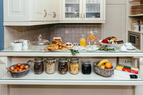 a kitchen counter with breakfast foods and jars of food at Hotel Kastro in Ioannina