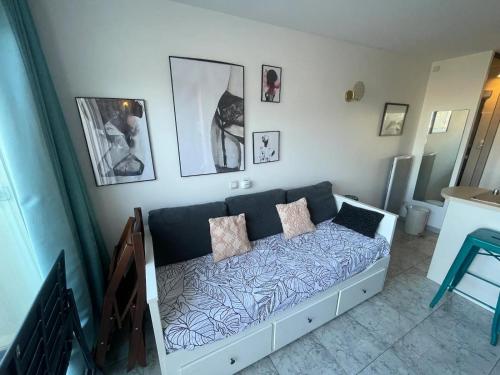- une chambre avec un canapé et des oreillers dans l'établissement Studio 'Soleil et Liberté' - Village Naturiste, au Cap d'Agde