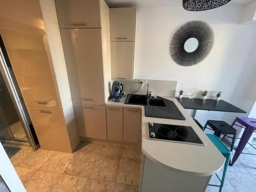 une cuisine avec un évier et une cuisinière four supérieur dans l'établissement Studio 'Soleil et Liberté' - Village Naturiste, au Cap d'Agde