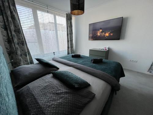 a bedroom with two beds and a flat screen tv at DELUXE APARTMENT (Free Parking) in Trenčín