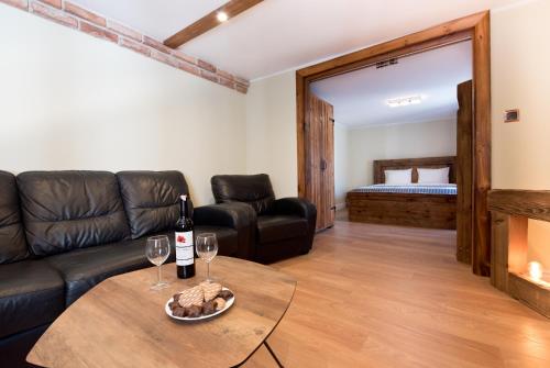 a living room with a couch and a table with wine glasses at Apartament Starówka no1, no2, no3 in Toruń
