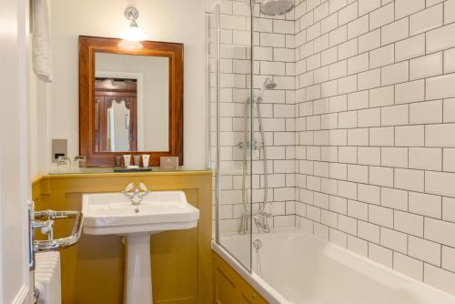 a bathroom with a sink and a tub and a toilet at Burley Manor in Burley