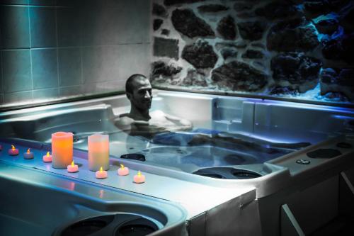 a man in a bath tub with candles in it at Hôtel Le Refuge in Tignes