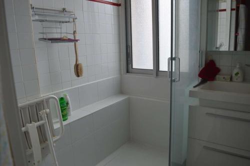 une salle de bain blanche avec une douche et un lavabo dans l'établissement Appart 2 pièces 4 couchages BANYULS SUR MER BN070-015, à Banyuls-sur-Mer
