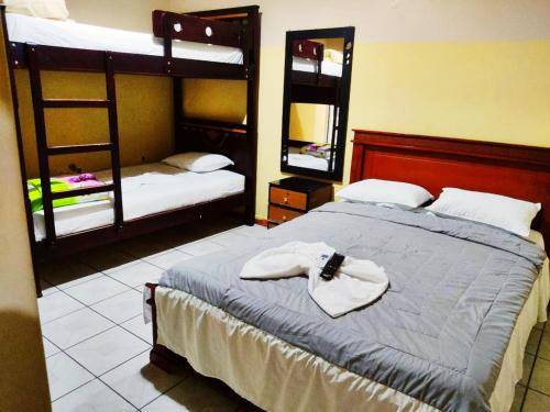 a bedroom with a bed with two bunk beds at Hospedaje Orquídeas 2 in Huaquillas