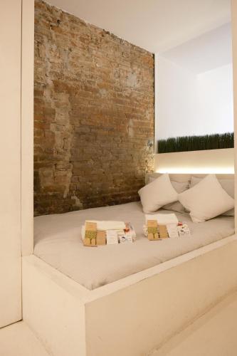 a bed in a room with a brick wall at La Chicca di Sant'Agata in Brescia