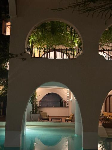 a house with a swimming pool with an archway over it at Hotel Carasco in Lipari