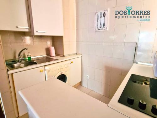 a small kitchen with a sink and a washing machine at Dos Torres Hobbiton- En el Corazón del Casco Histórico in Zaragoza