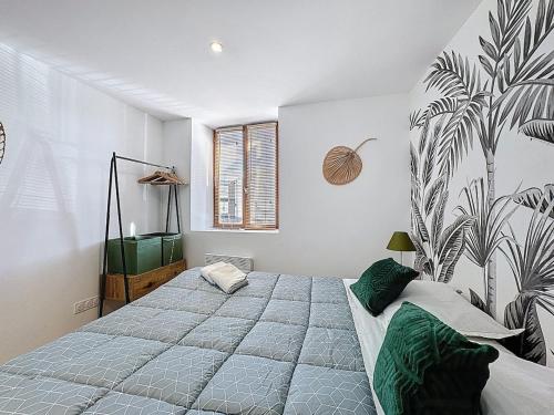 a bedroom with a large bed with a large plant mural on the wall at Cocon cosy proche aéroport Tout équipé Aulnat3 in Aulnat