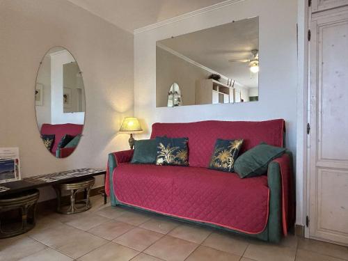 - un canapé rouge dans le salon avec un miroir dans l'établissement Appart 2 pièces 4 couchages BANYULS SUR MER BN010-004, à Banyuls-sur-Mer