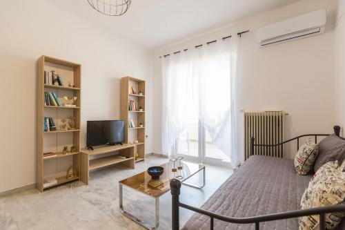a living room with a bed and a tv at Cozy studio 300m from the beach and city center, free parking in Áyios Andónios