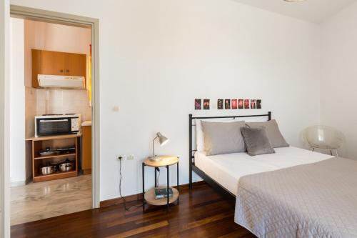 a bedroom with a bed and a table with a lamp at Cozy studio 300m from the beach and city center, free parking in Áyios Andónios