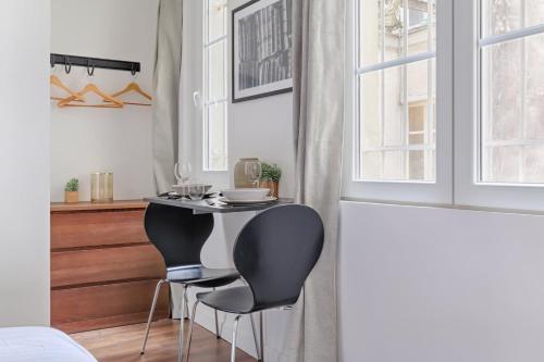 une petite cuisine avec une table et deux chaises dans l'établissement TBS 308 - Beautiful studio near Marais district, à Paris